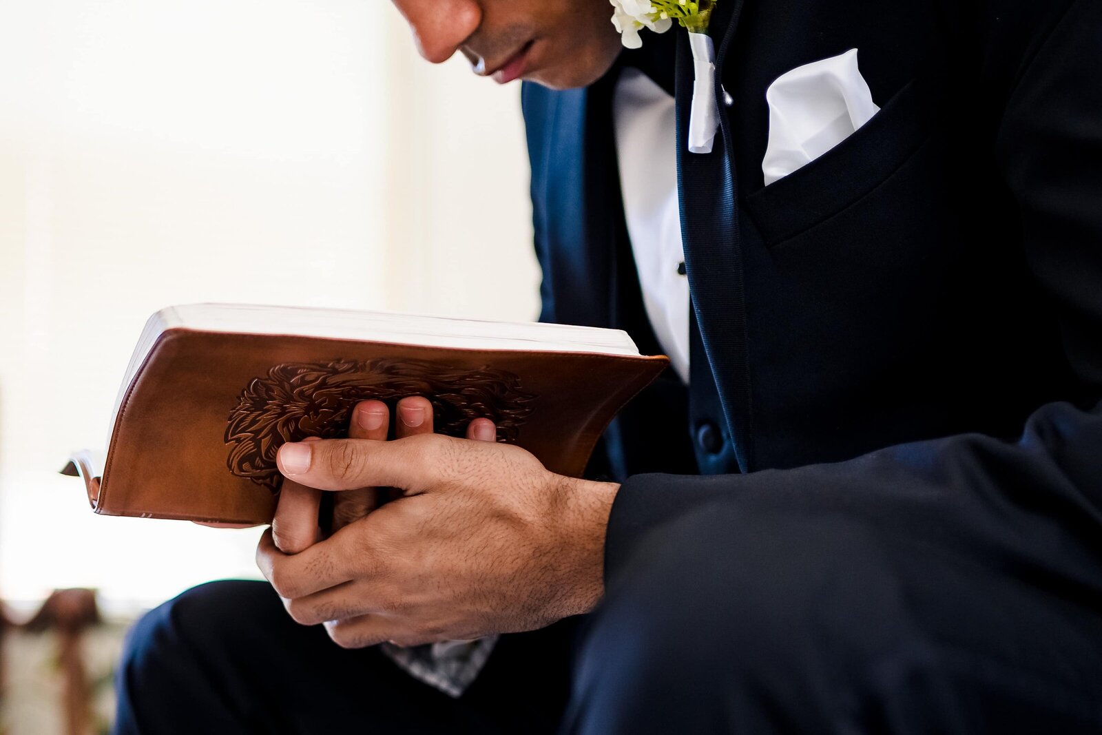 groom prays with his bible before the wedding ceremony