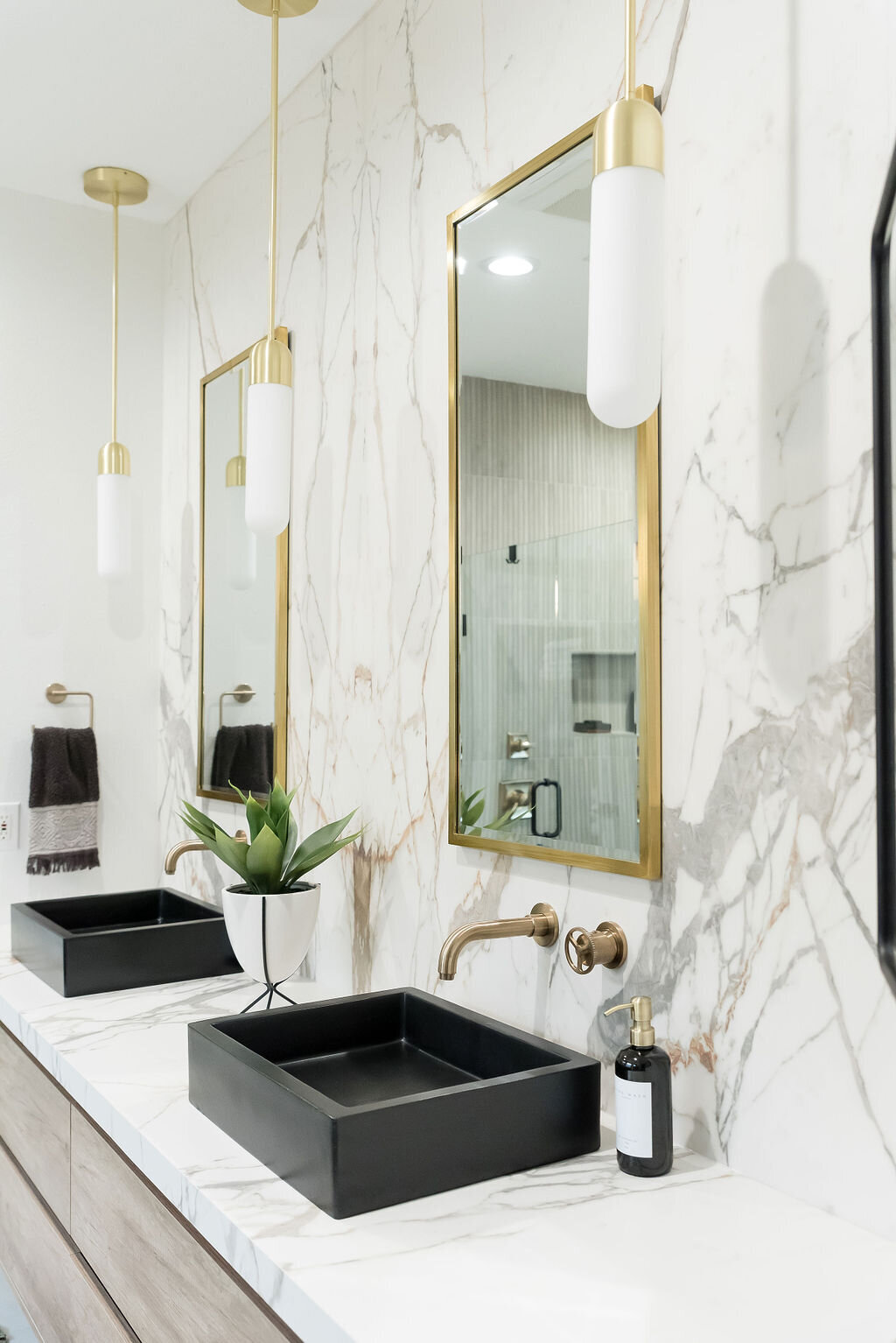 dewine design interiors hotel lux bathroom double black sinks and gold framed mirrors