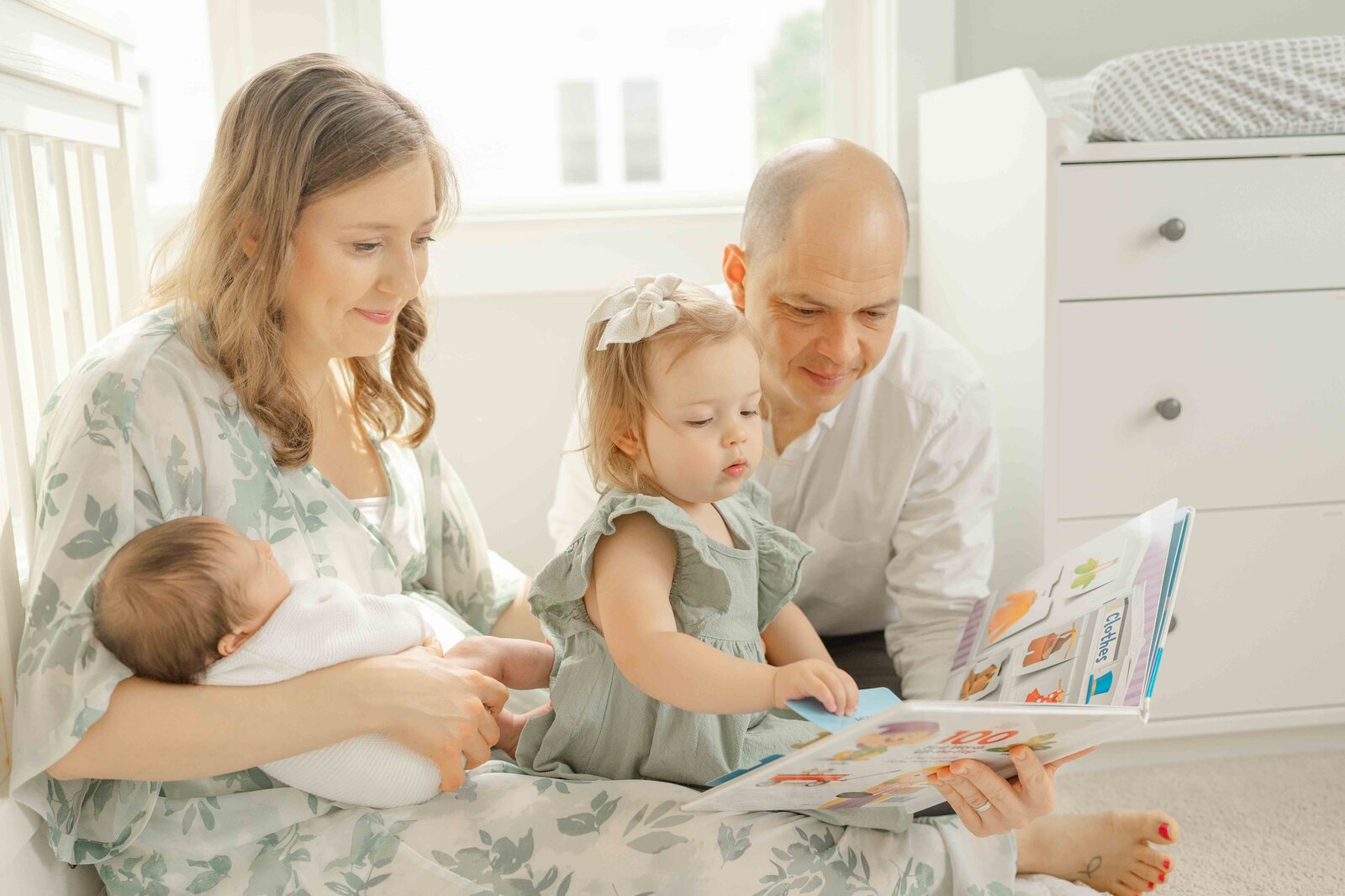 big sister reading a book during Centreville, VA newborn photo