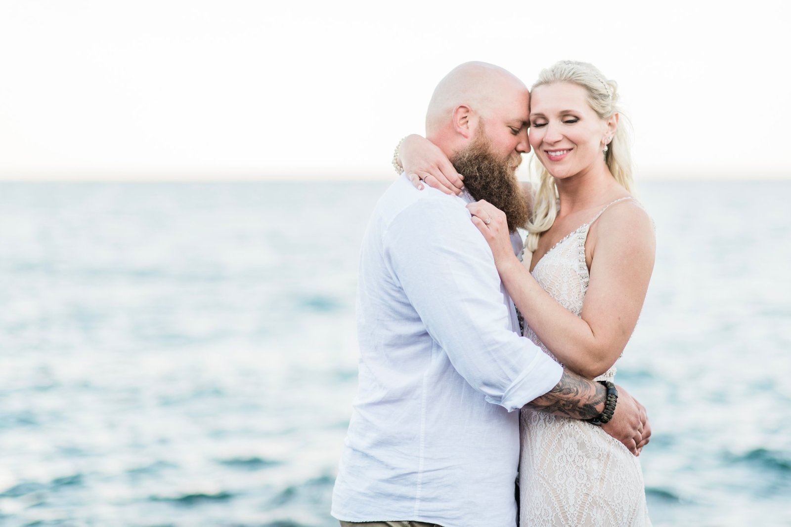 A couple snuggle along the shores of Lake Superior following their Minnesota wedding.