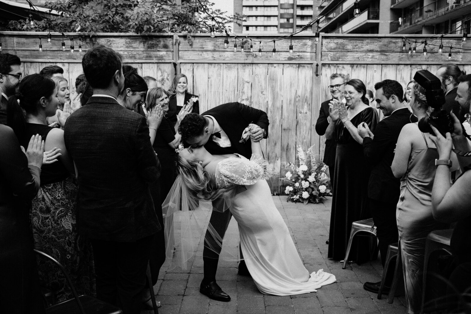 Newly wedded couple in a dip kiss at the end of their wedding ceremony.