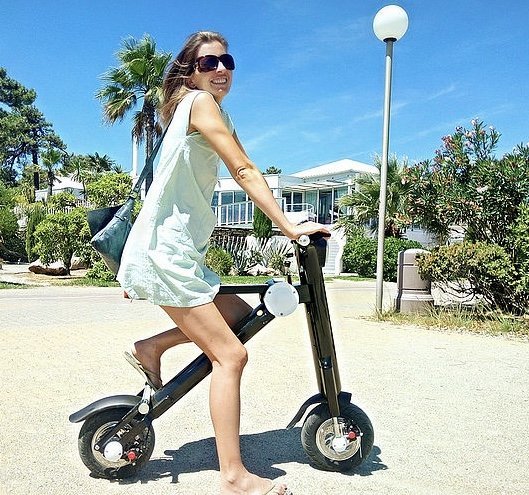 Lady sitting on a Black Go-Bike M1 at the Beach