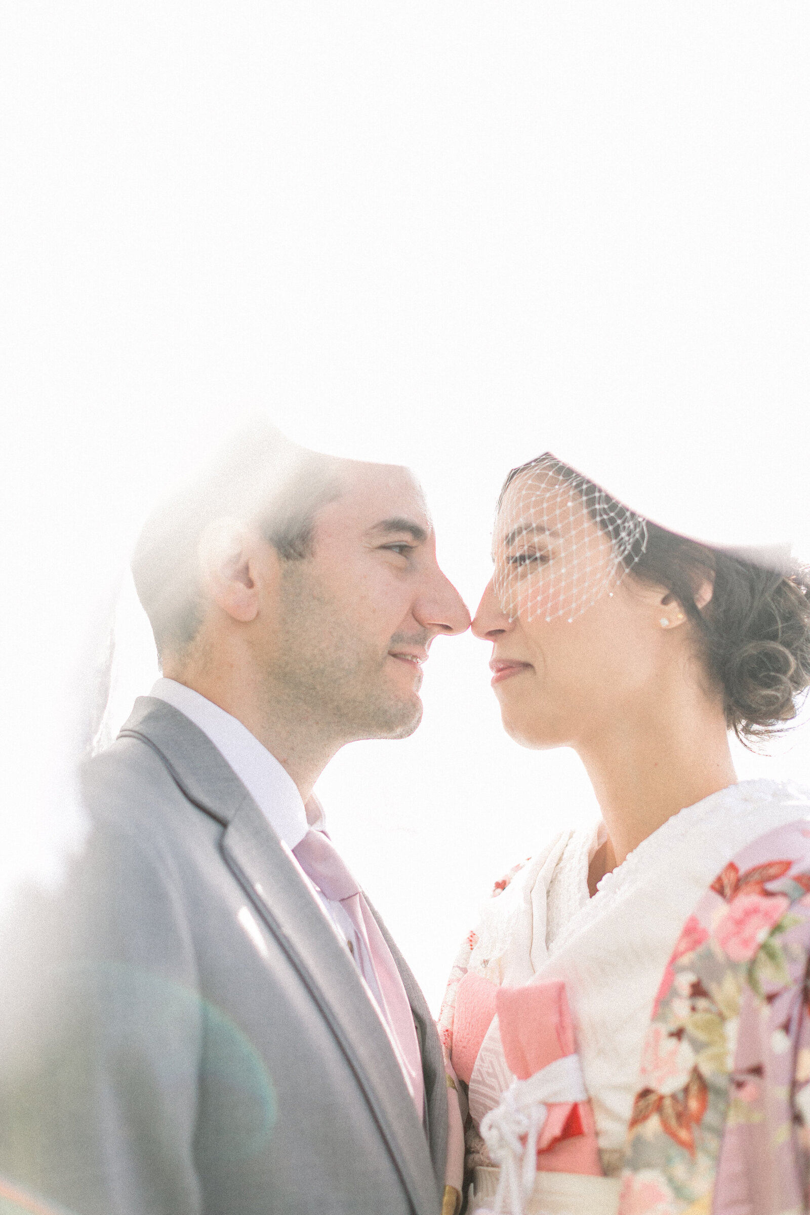 Romantic close-up of bride and groom under the veil, bride in a pastel floral wedding kimono at The Ebell Club Long Beach, kimono rental Los Angeles | ロサンゼルスThe Ebell Club Long Beachでベール越しに見つめ合う花嫁と新郎、淡い花柄の着物レンタル花嫁