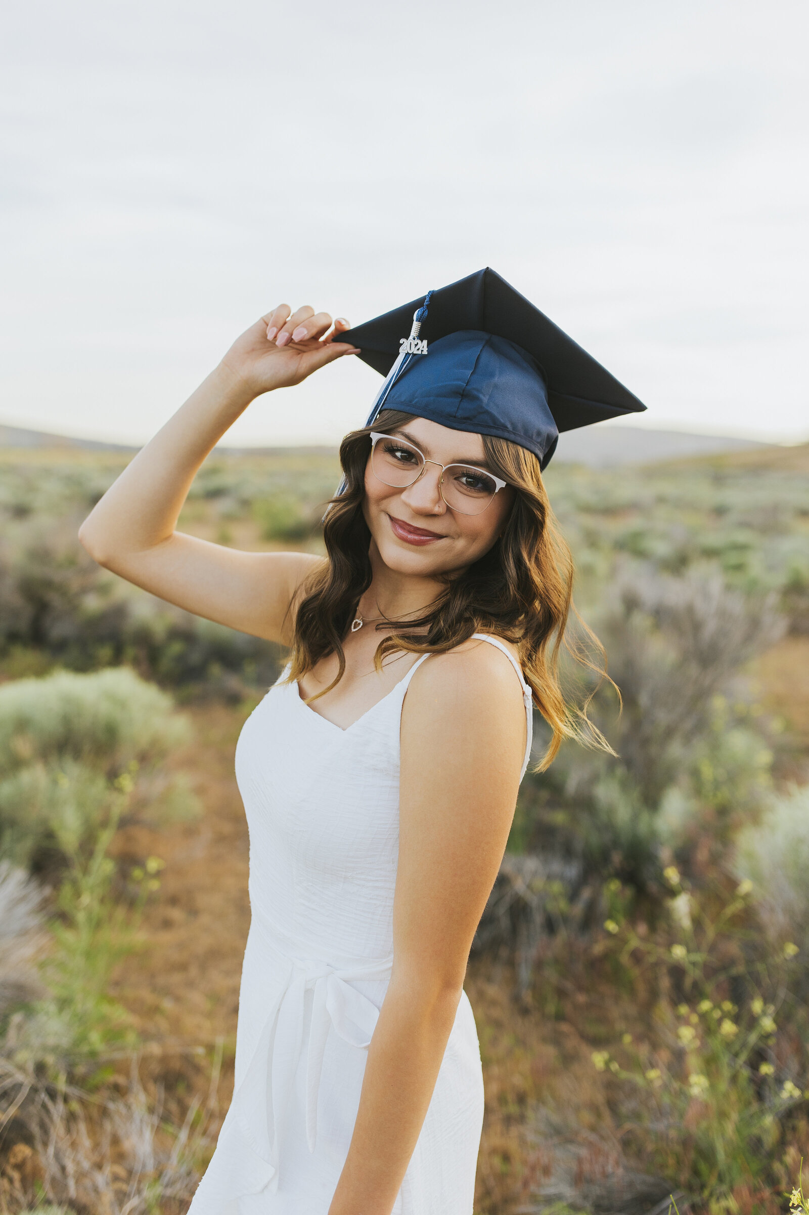 Senior girl holding cap outdoor portrait session