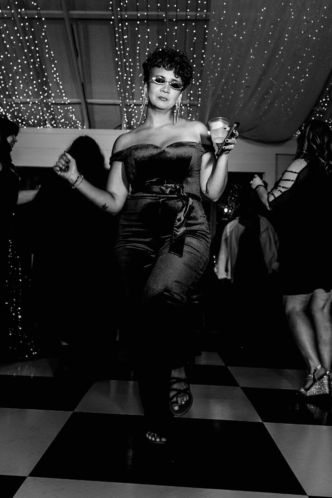 woman in velvet jumpsuit dancing on dance floor