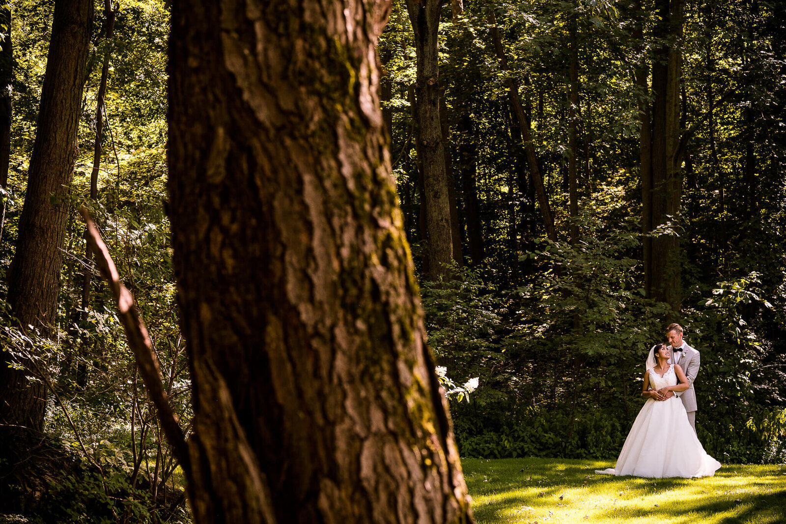 Candid photo of bride and groom with forest setting.