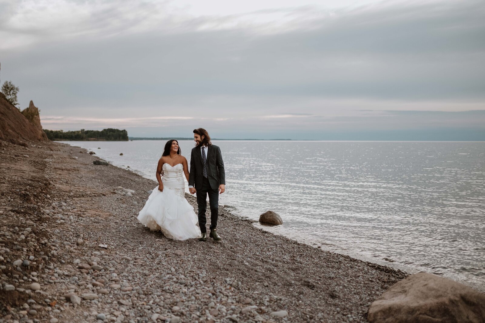 Newlywed couple walking along the shore