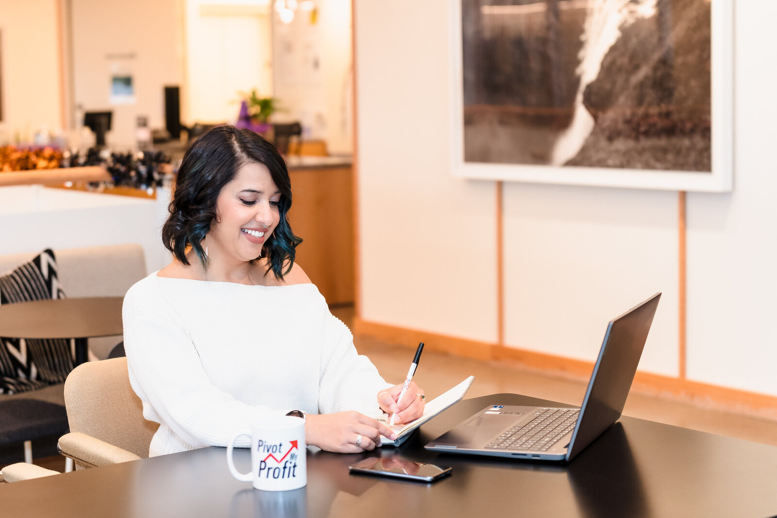 Business Coach takes notes in front of a laptop