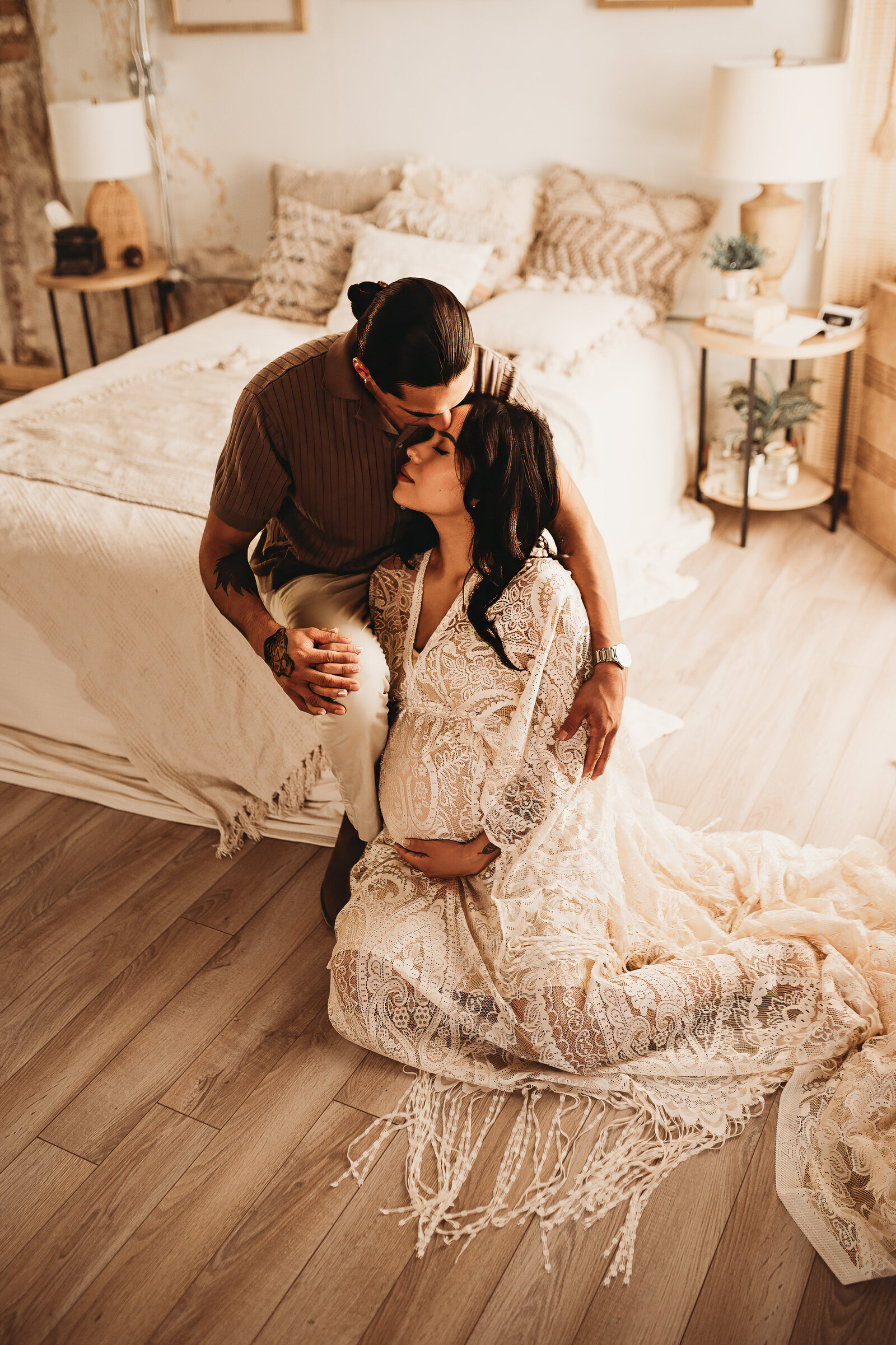 A young couple embraces while taking in a sweet moment together during a maternity studio session at Nikii Pix Photography Studio. 