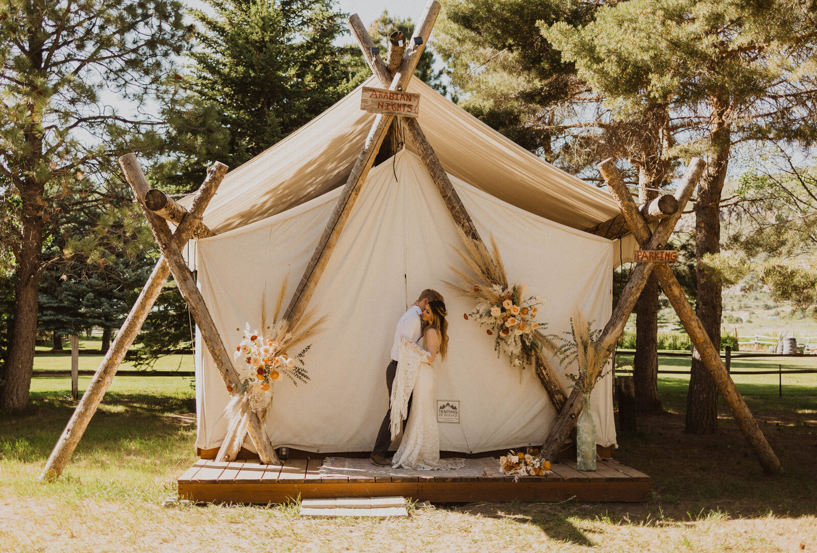 A couple in wedding attire at a boho canva tent