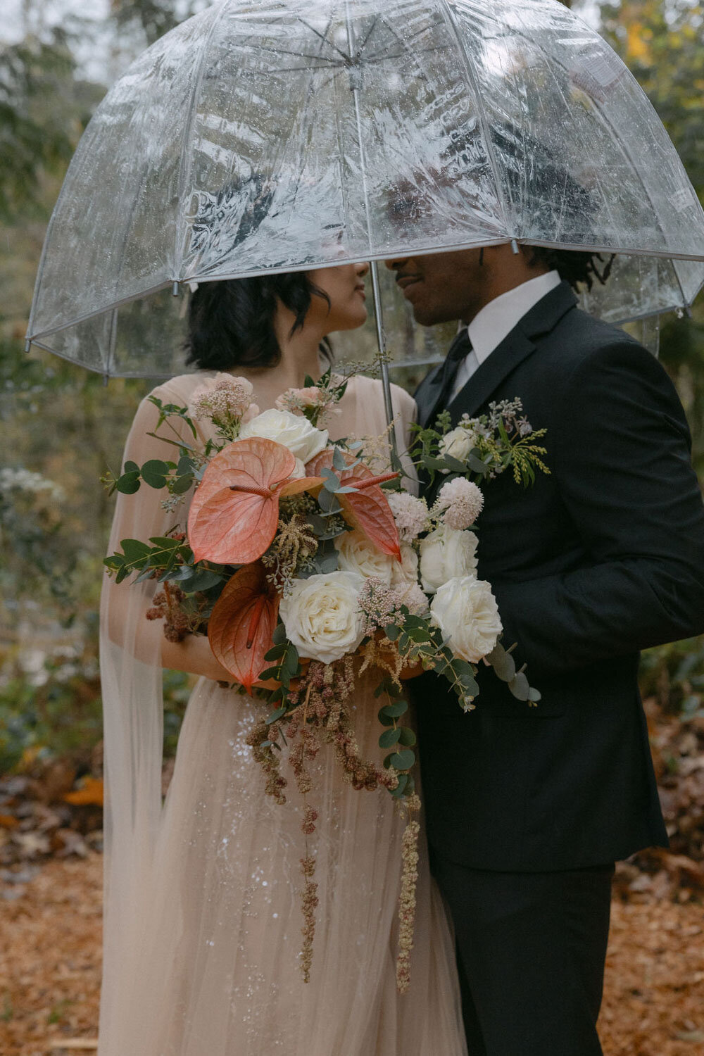Bride and groom under a clear umbrella