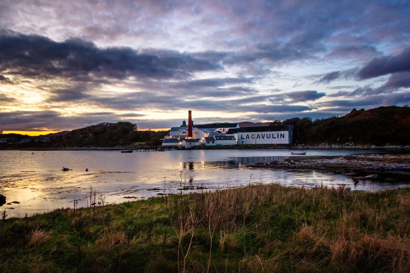 Lagavulin Distillery on Scotland’s Isle of Islay, known for its rich, peaty single malt whisky. Kelsey Parry Travel curates the best food and drink experiences.