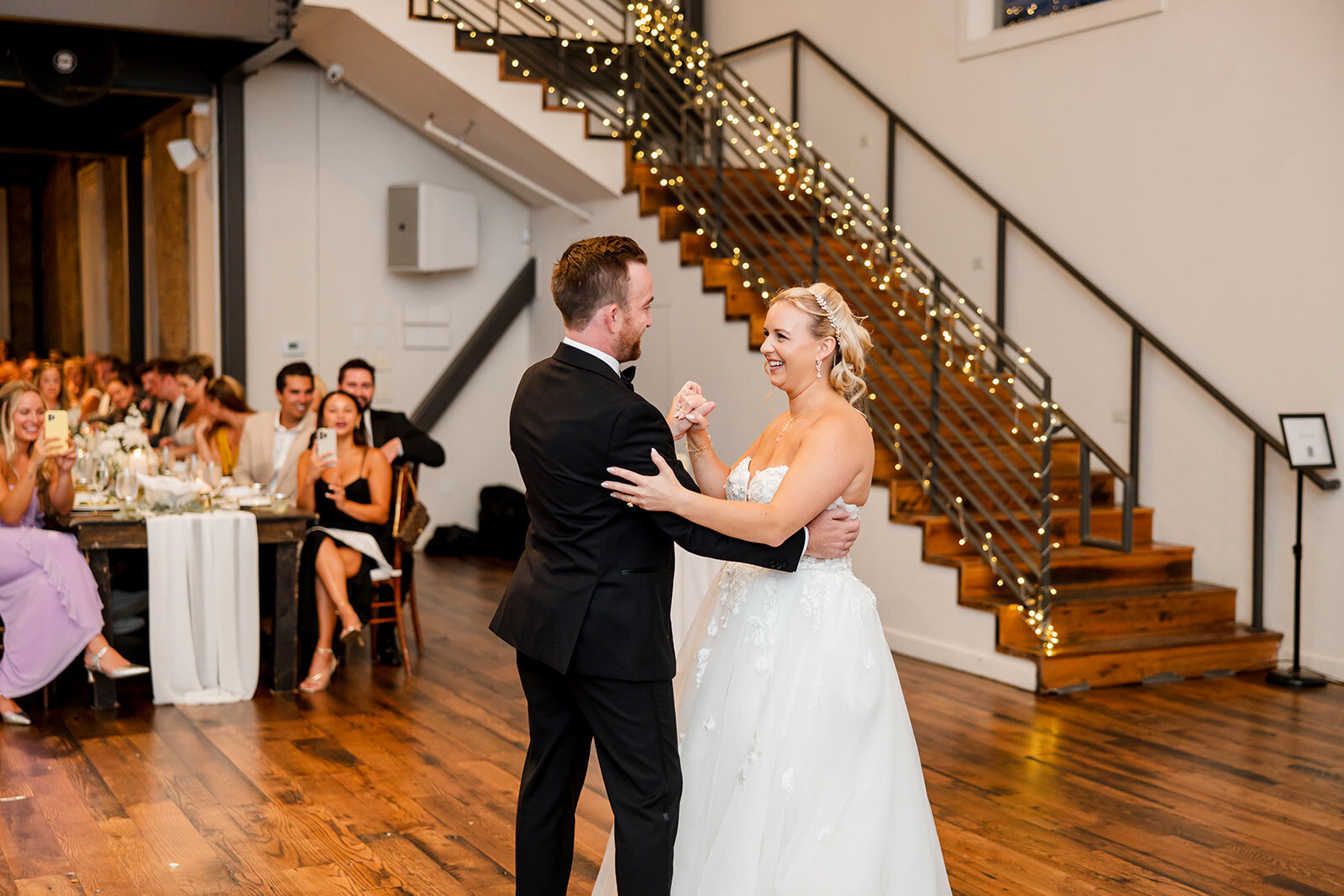 Bride and groom dancing in the hall with grand staircase
