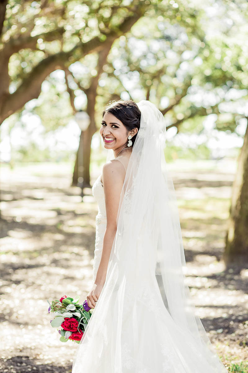 Bride stands under oak trees in White Point Garden, South Carolina
