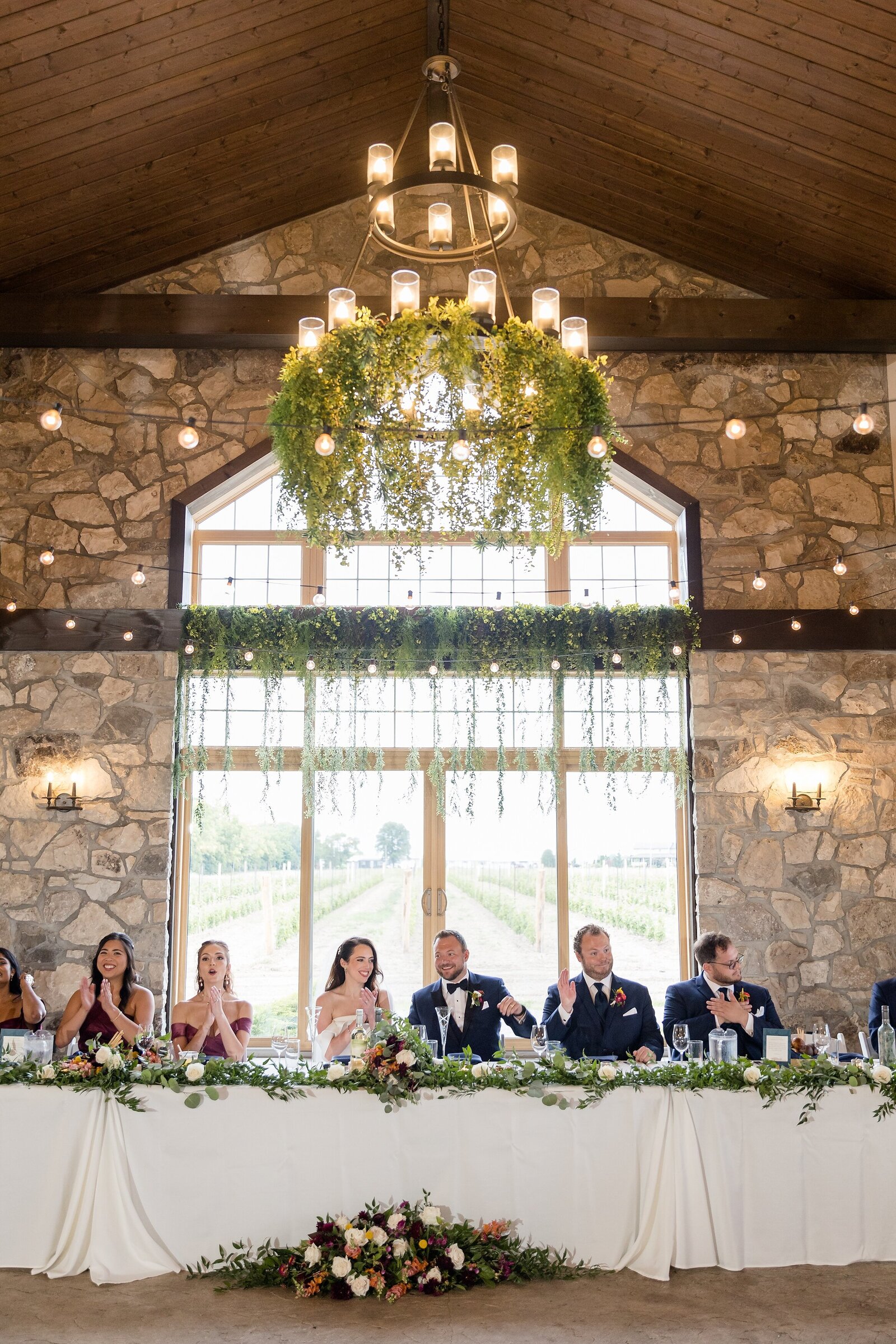 Bride-and-Groom-sit-at-head-table-with-their-wedding-party-at-their-Sprucewood-Estate-Winery-Reception