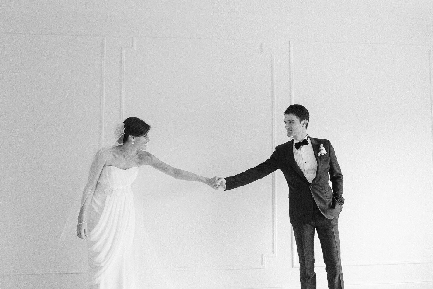 A happy newlywed couple holding hands. They look beautiful and elegant. Romantic wedding.