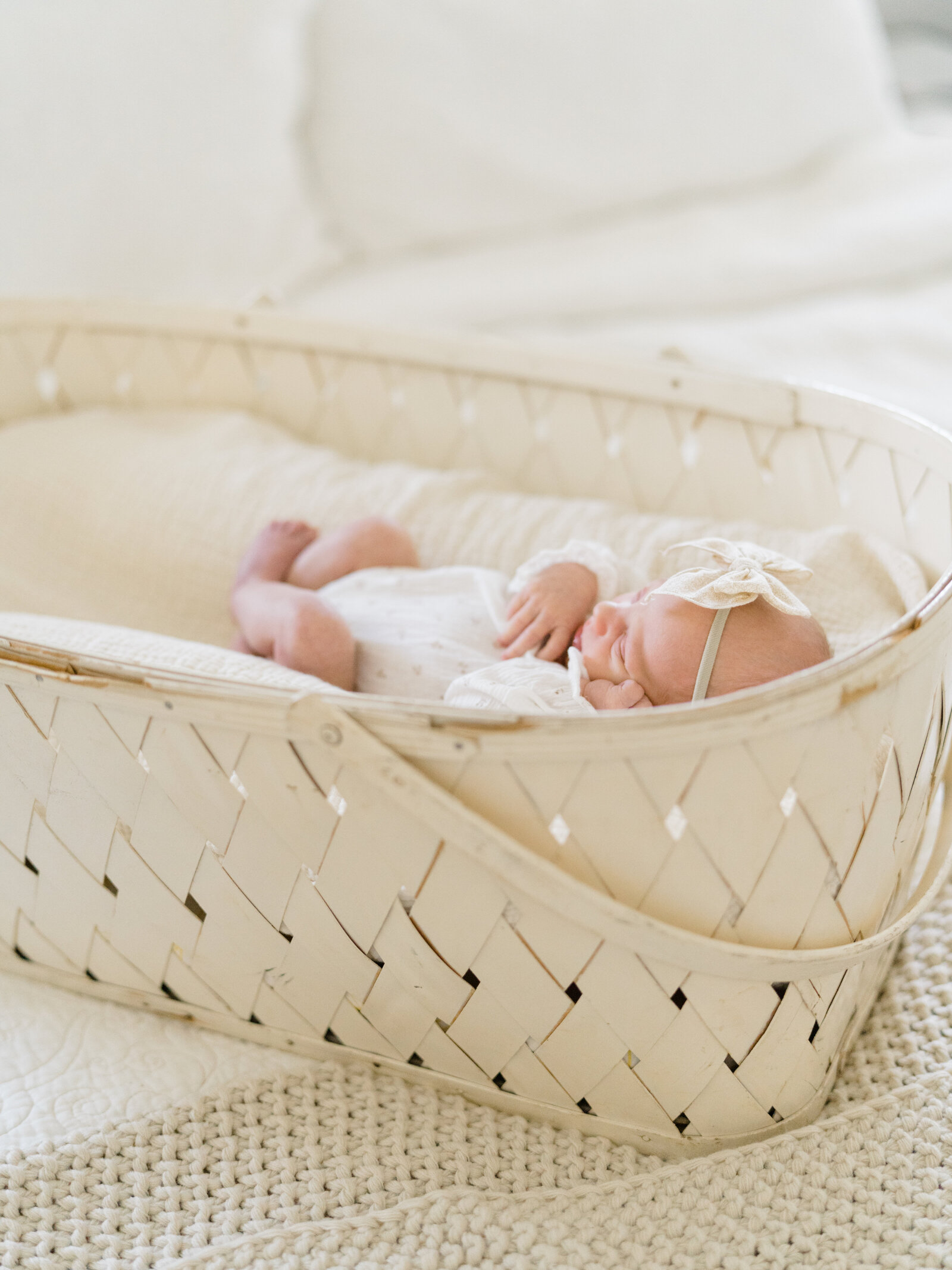 newborn baby girl sleeping in a white basket