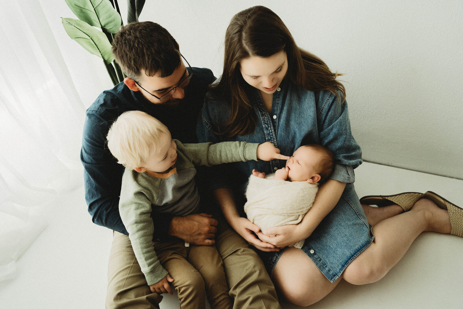 Mom, Dad, Big Brother and Baby Brother snuggling together in a Pardeeville, Wisconsin newborn session.