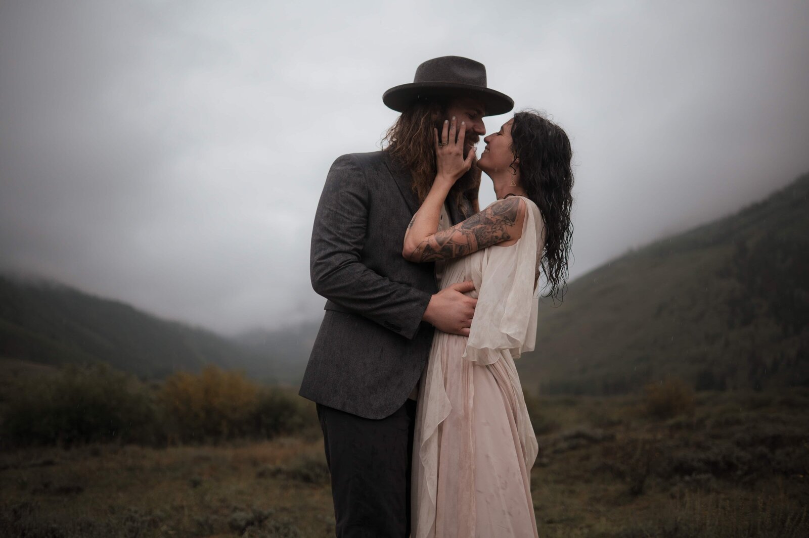 Couple eloping in the Scottish Highlands with rolling hills and mist

