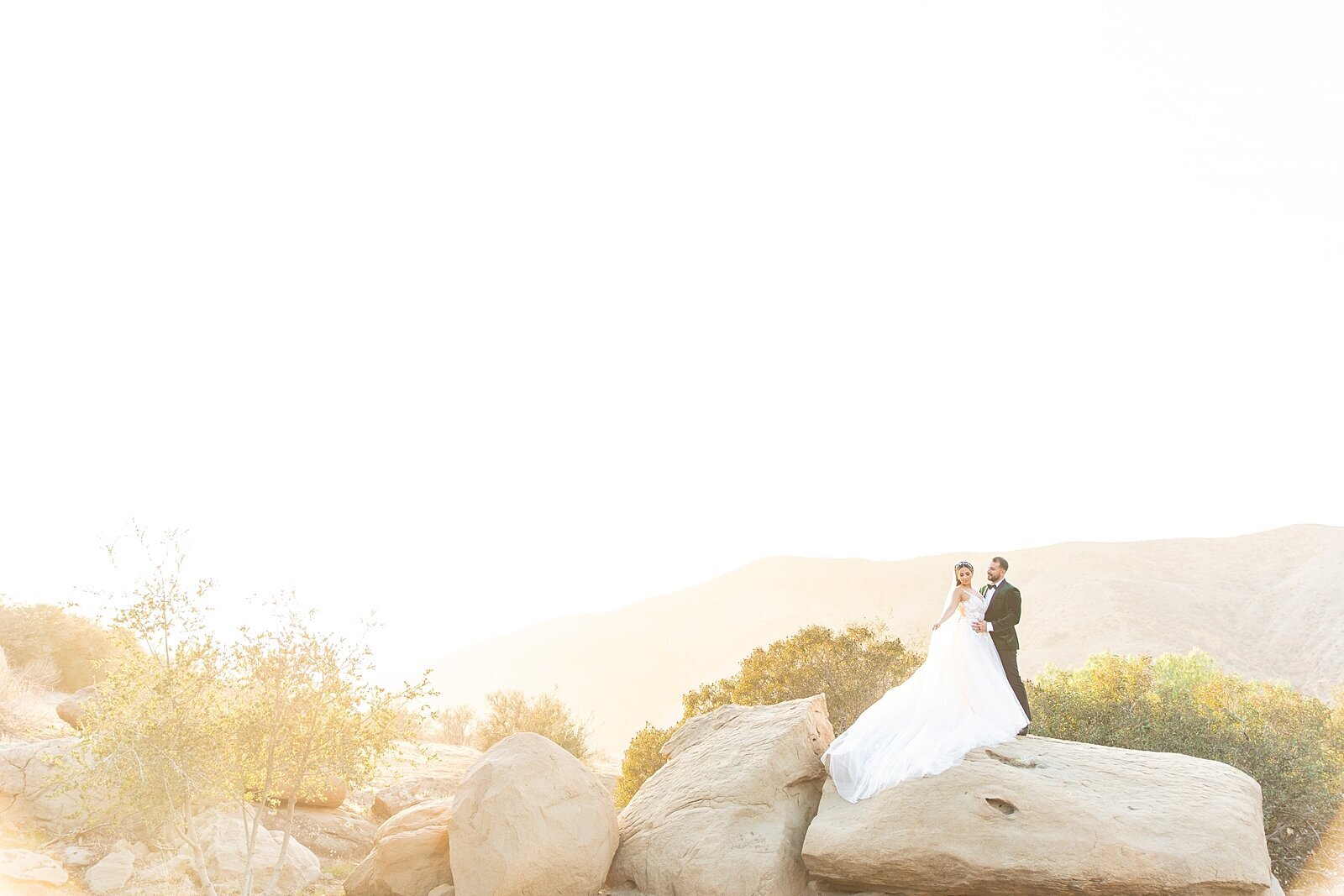 Bride & groom kissing on mountaintop  at Hummingbird Nest Wedding Venue in Santa Susana, California. | Sherr Weddings