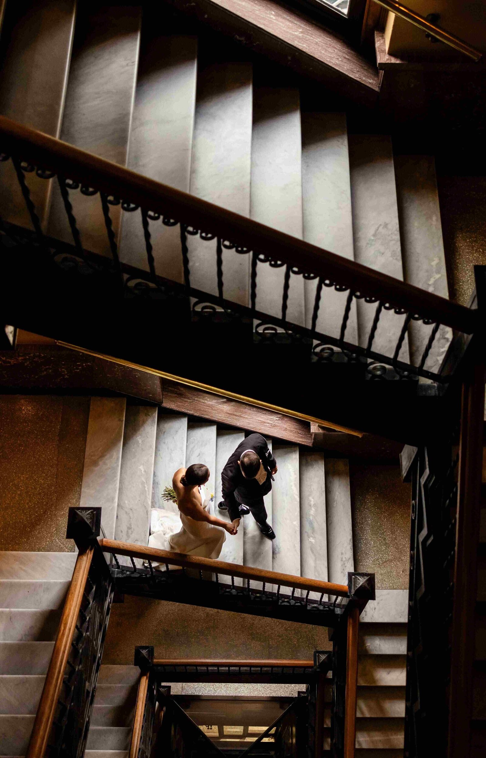 bride and groom walking down staircase photographed from above