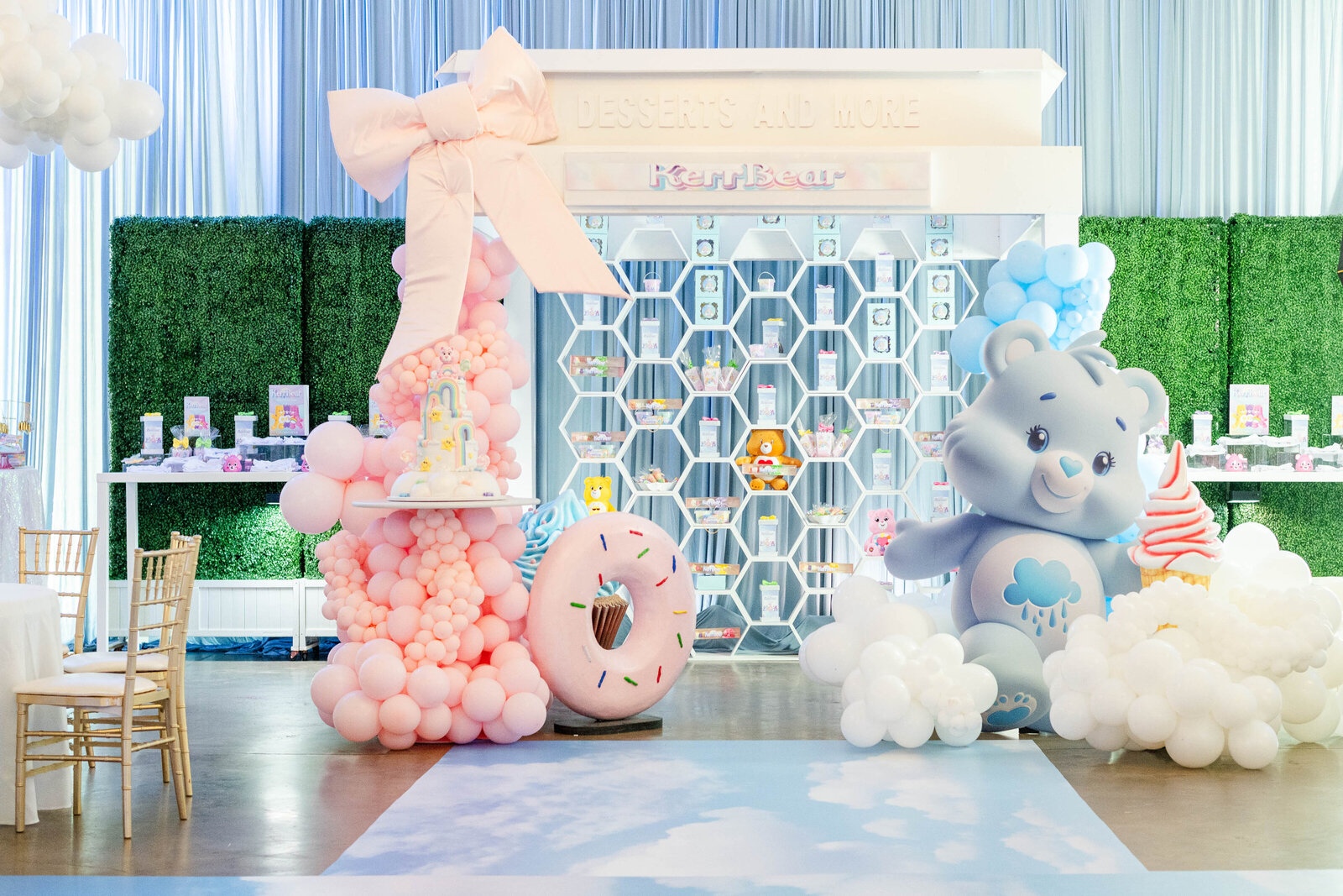 Care Bears-themed kids birthday party dessert display with pastel balloons, custom cake, candy wall, and playful decor by luxury event designer Wells Design Co.