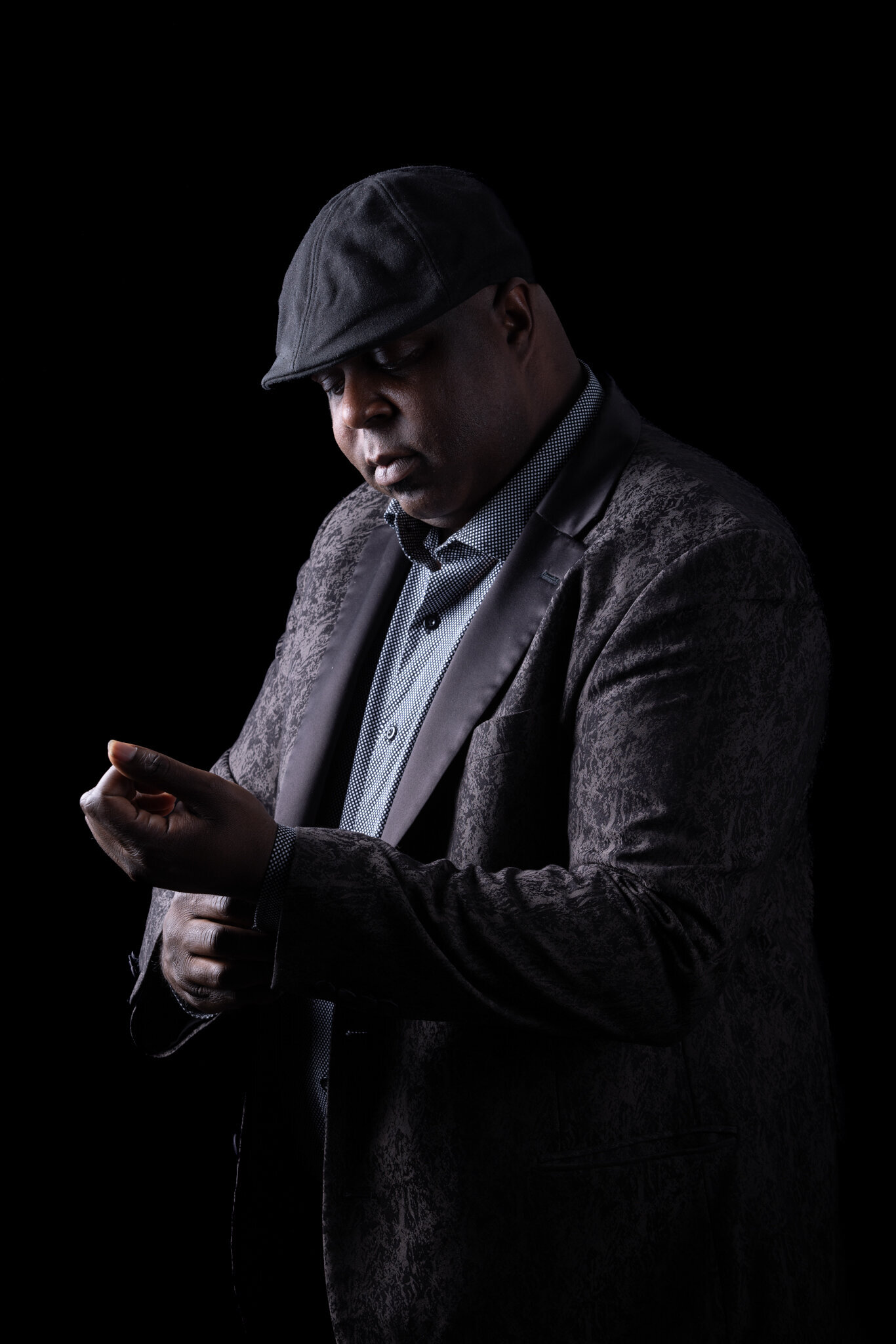 Walt from Charizma Entertainment in profile with microphone in dramatic studio lighting