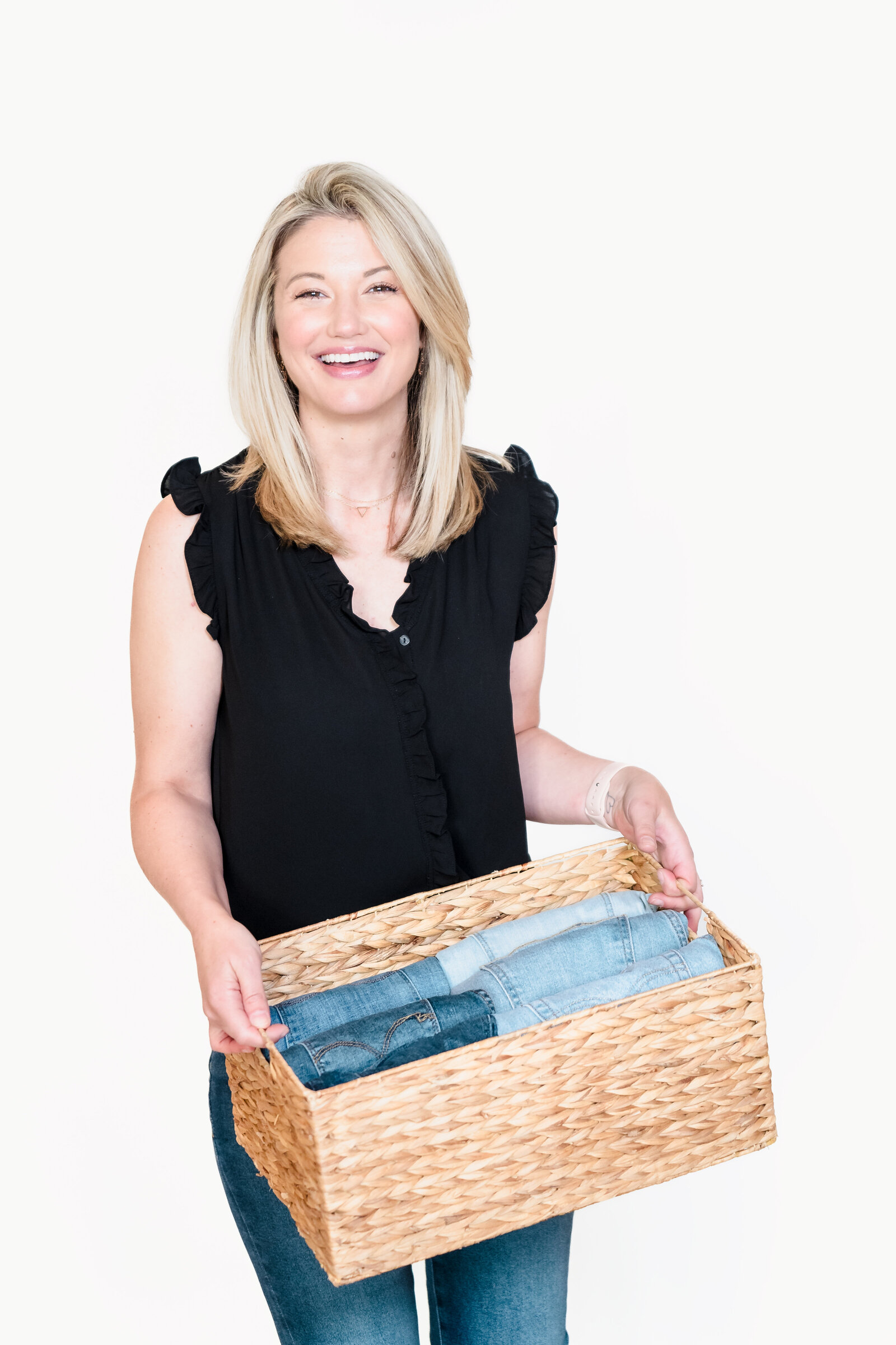 brand photo of a professional organizer holding a box full of the pants folded