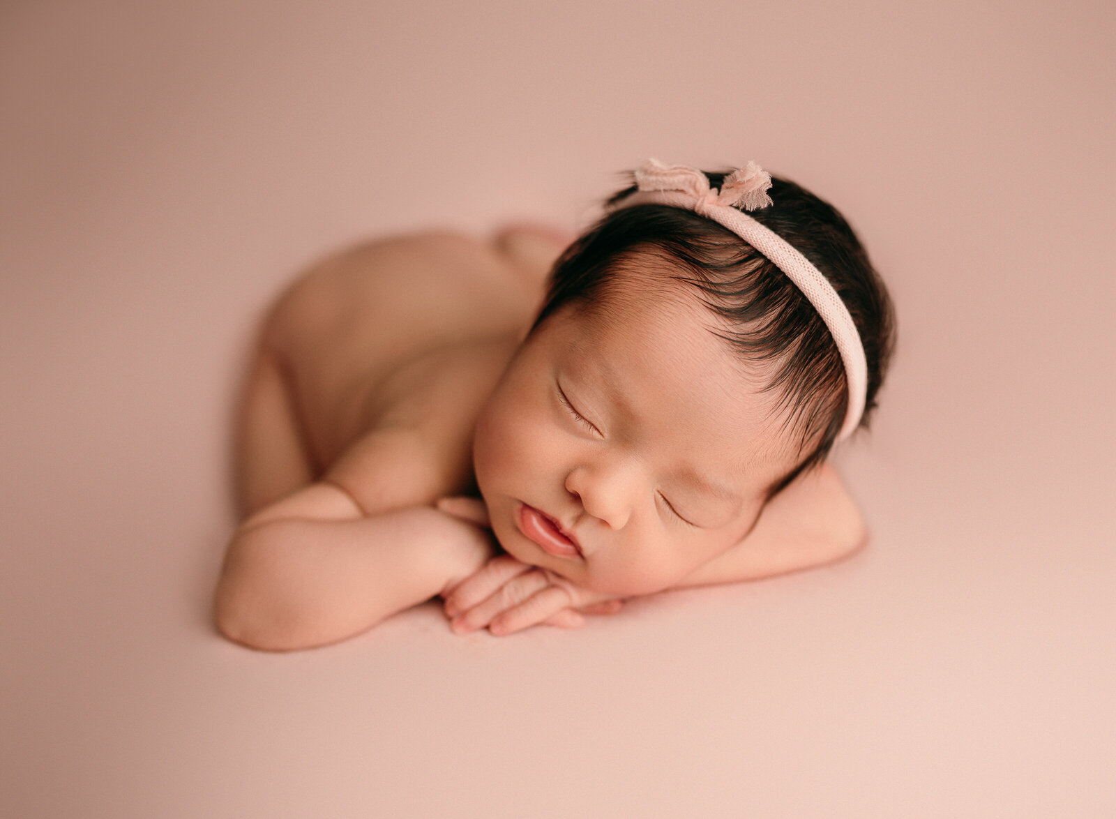 chin on hands newborn posing