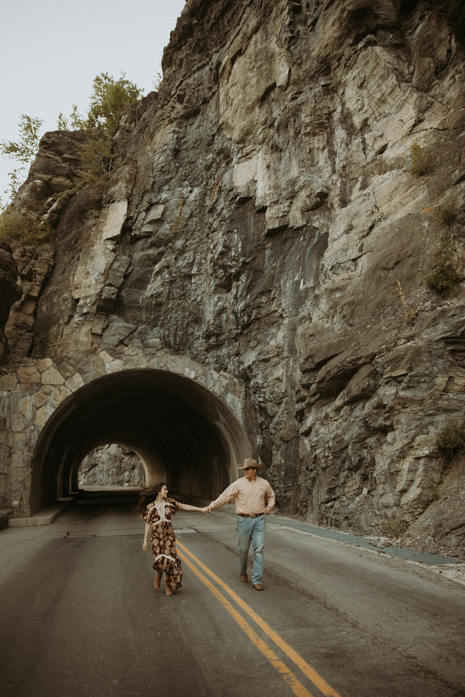 couple walking in the middle of the road during their couples photos in montana