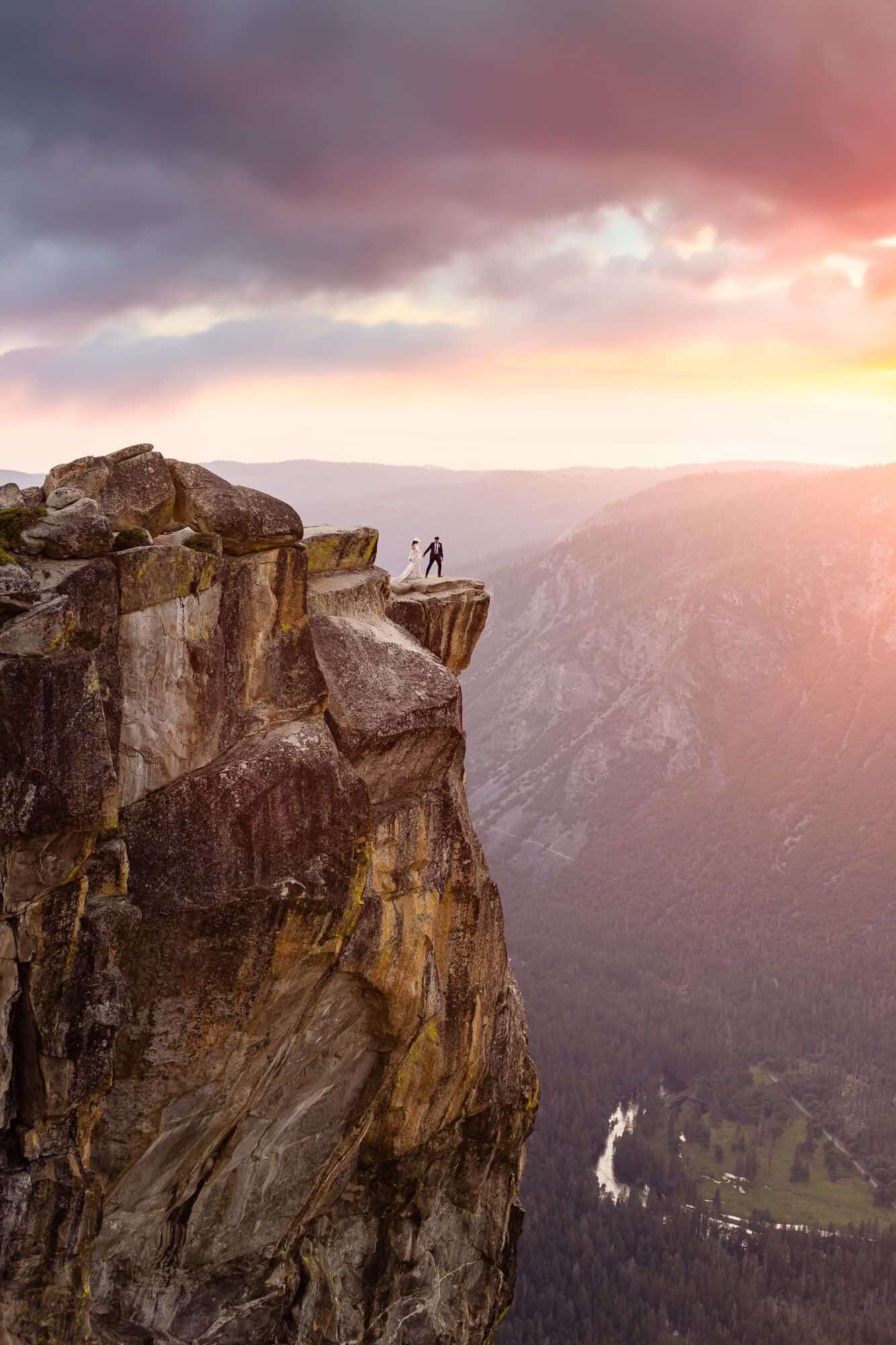 A bride and groom enjoy a sunset on their Yosemite elopement day from the epic view at Taft Point in Yosemite National Park.