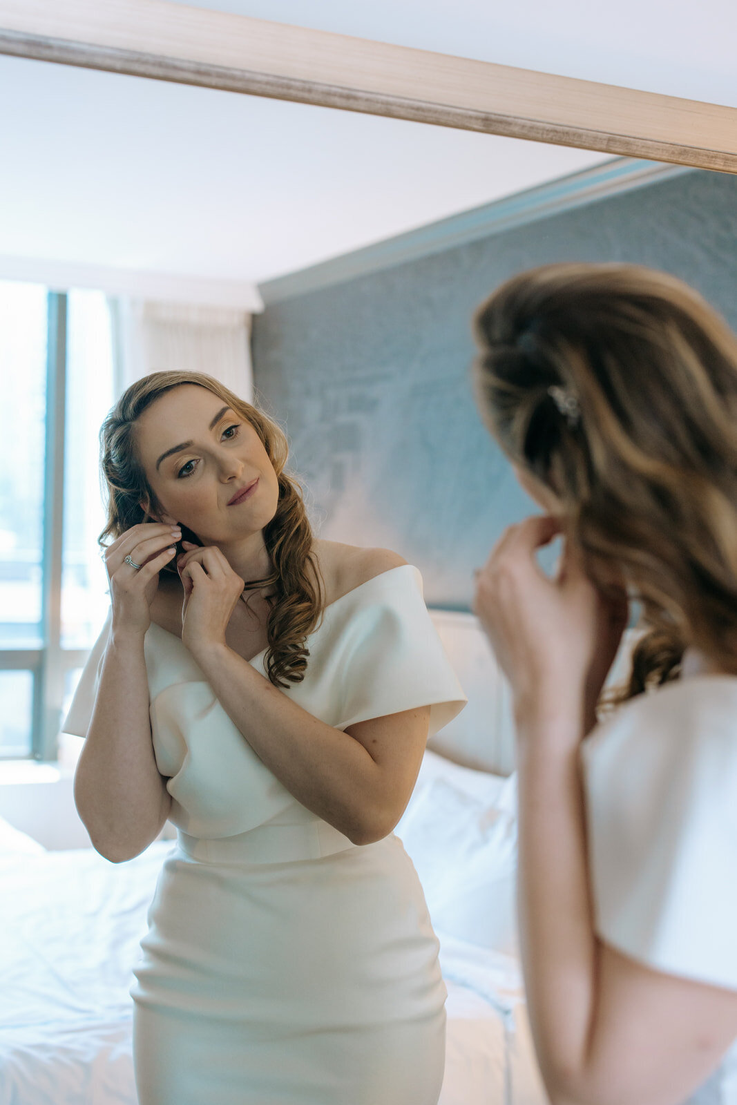 bride-getting-ready-earrings-in-mirror