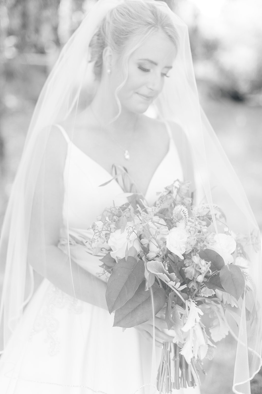 Black and white image of bride in veil holding bouquet taken by the Best Boise Wedding Photographers