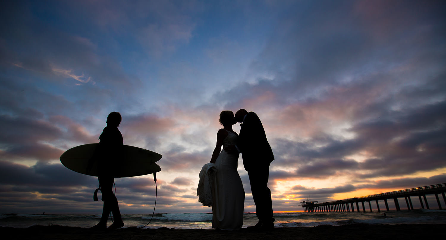 sunset silhouette with surfer in back ground