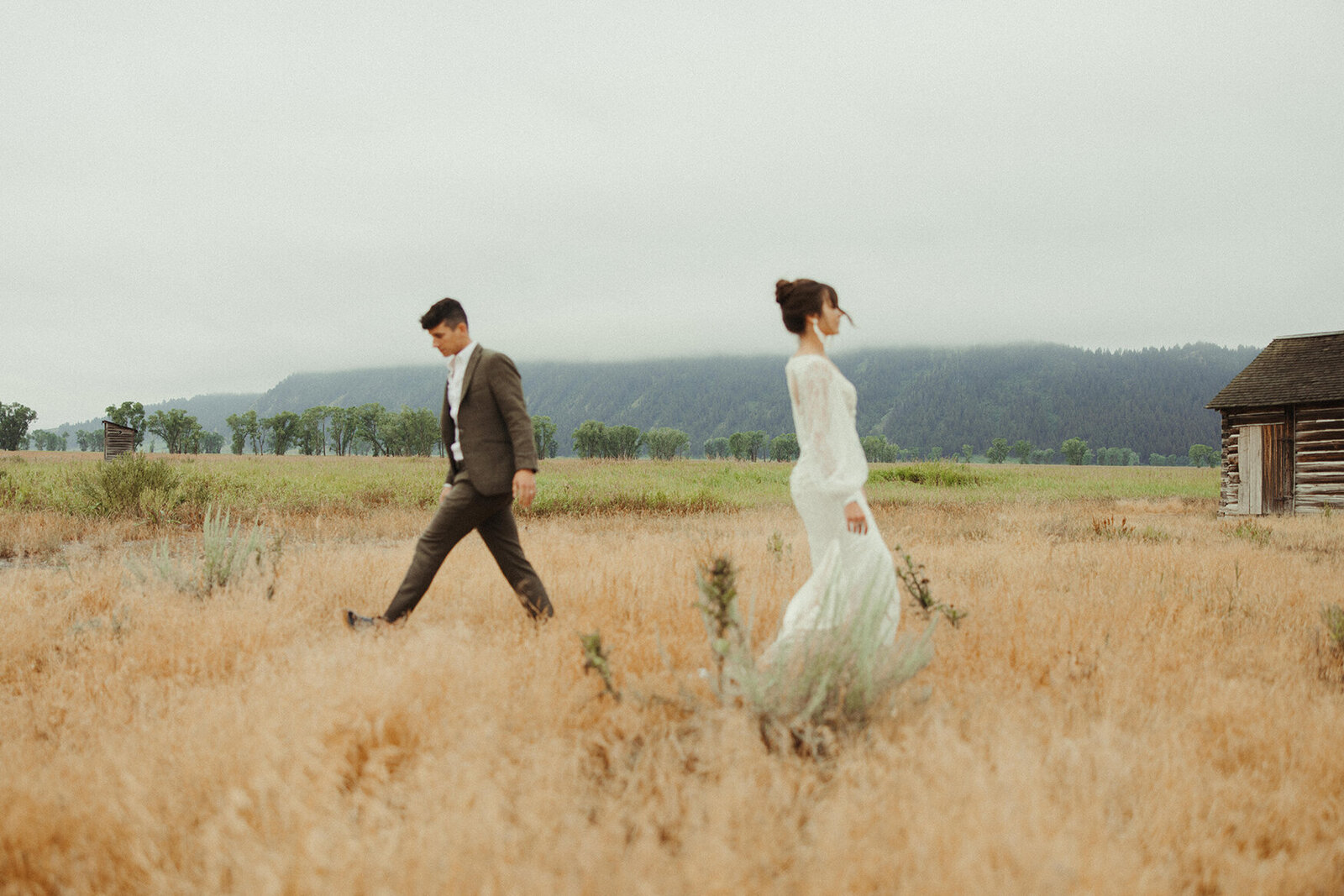 bride and groom walking in field