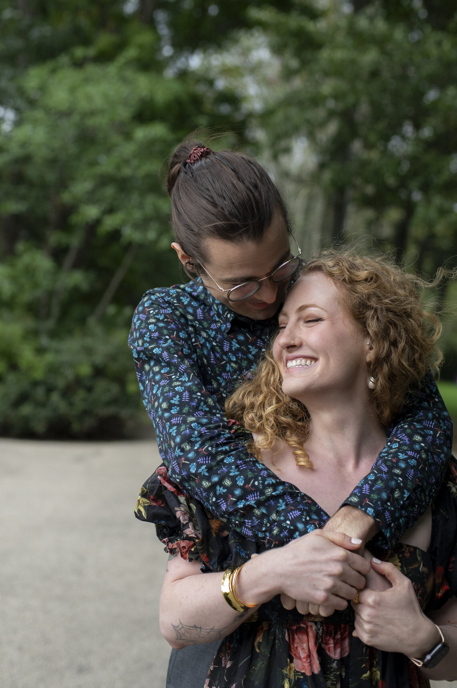 A person hugging their partner from behind as they smile 