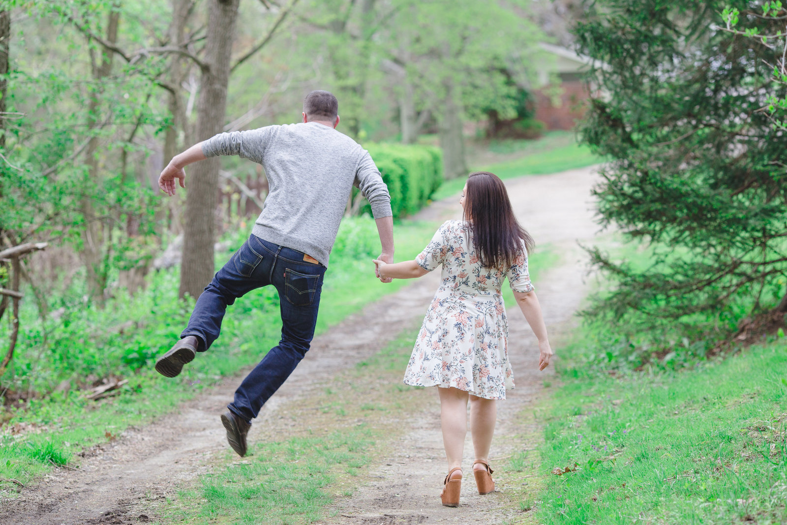 engaged_couple_skipping_in_park