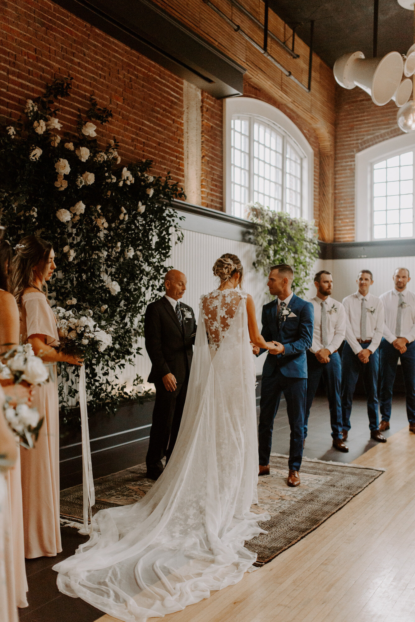 Wedding ceremony of the bride and groom while entourage looking at them at the Evergreen