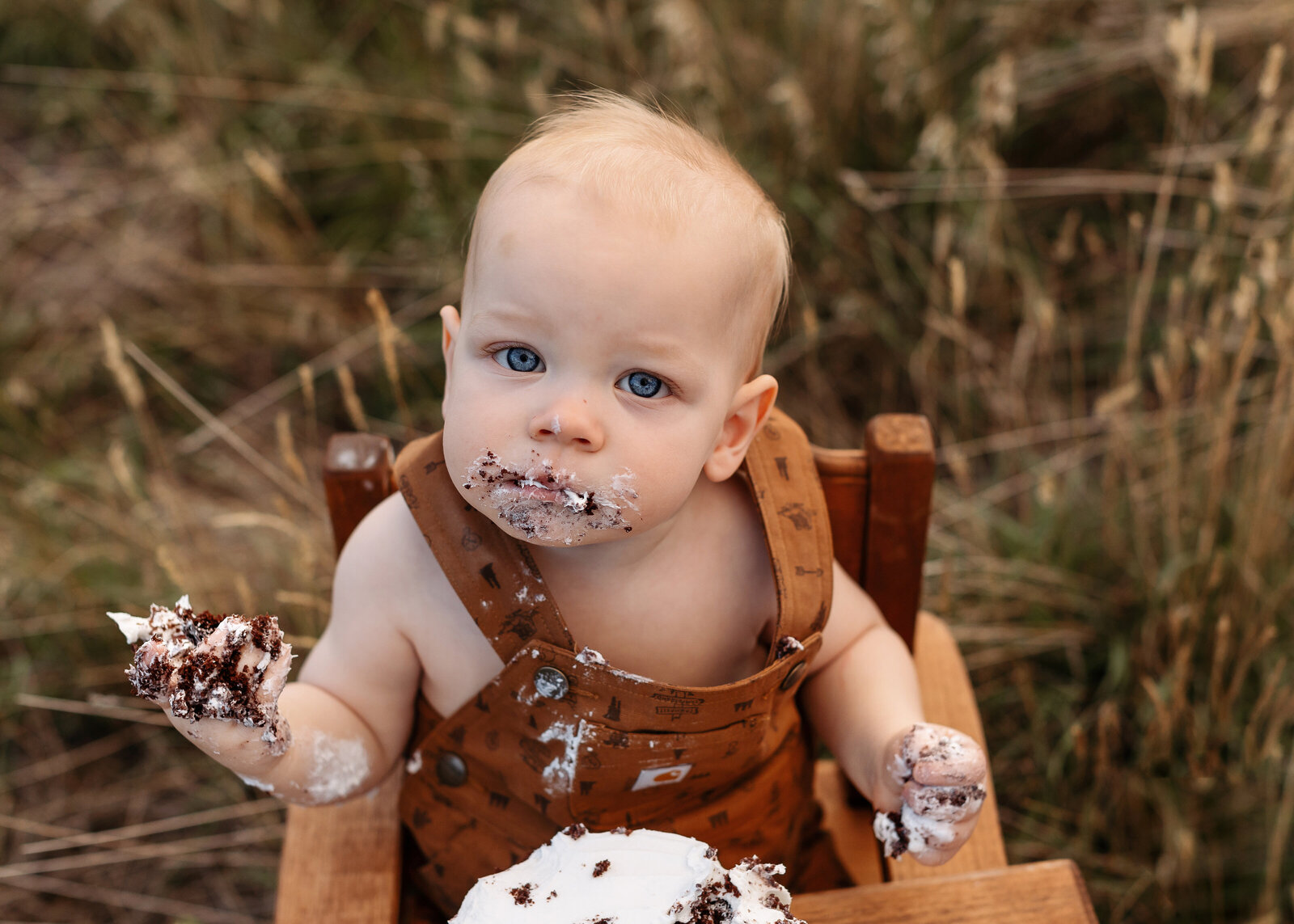 baby eating his chocolate cake outdoors for a smash cake session