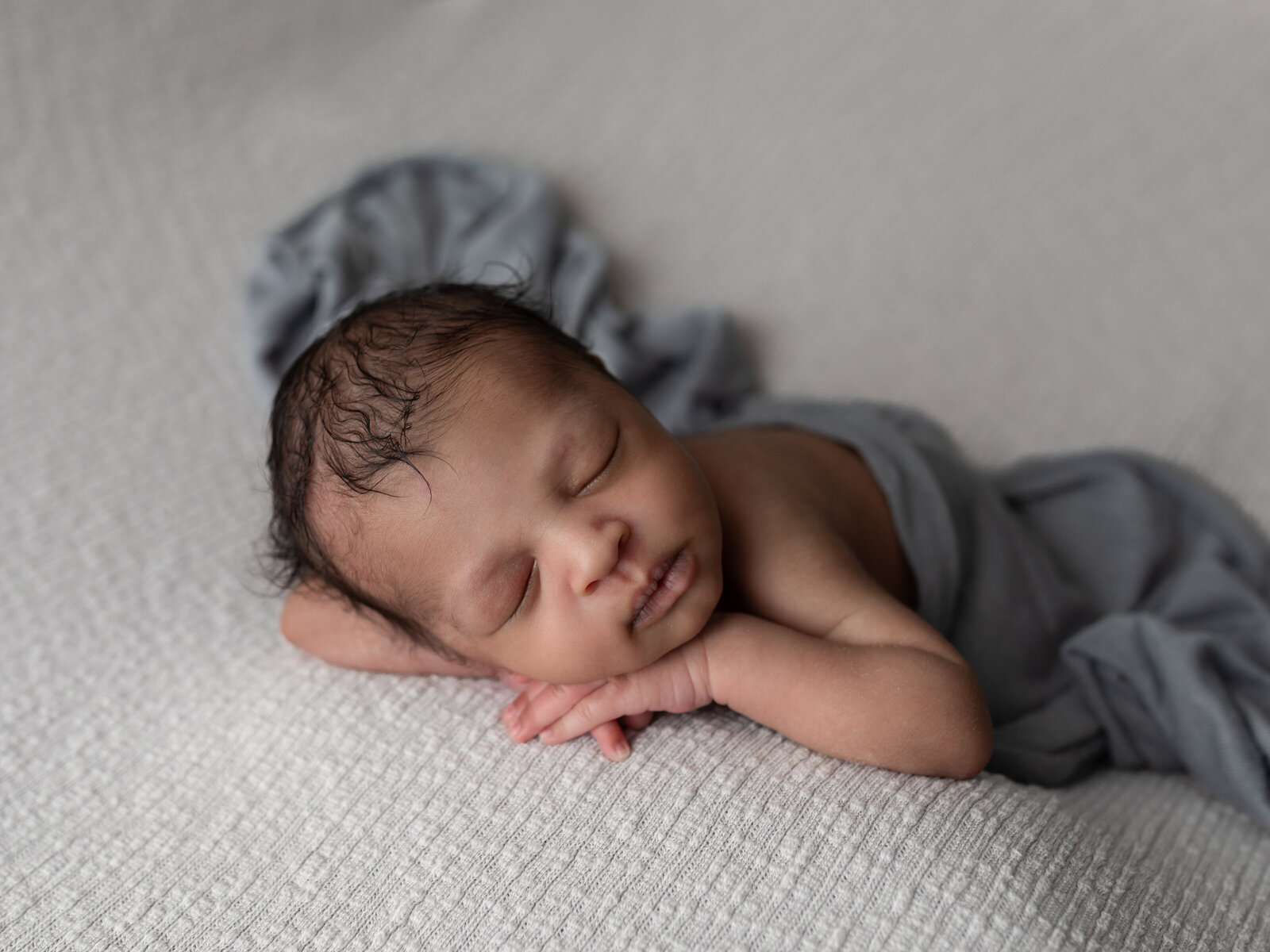 newborn baby boy posed on gray fabric for studio portraits cleveland newborn photographer