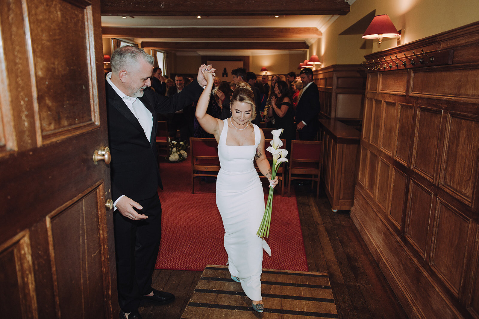 Bride and groom walking out of their wedding ceremony in Cambridge photographed with direct flash
