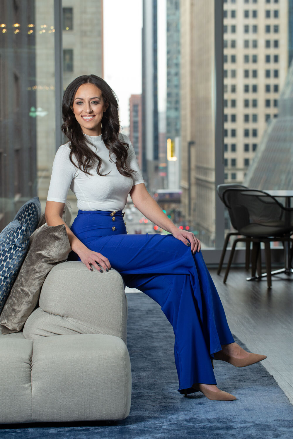 Woman sitting on a modern sofa in a high-rise office lounge