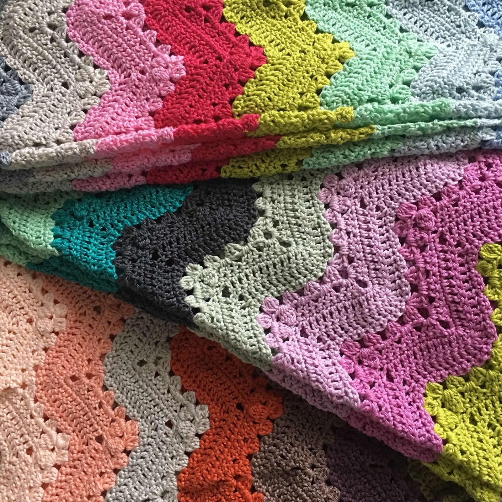 Hand crocheted colorful blanket folded to show the zig zag design and colors.