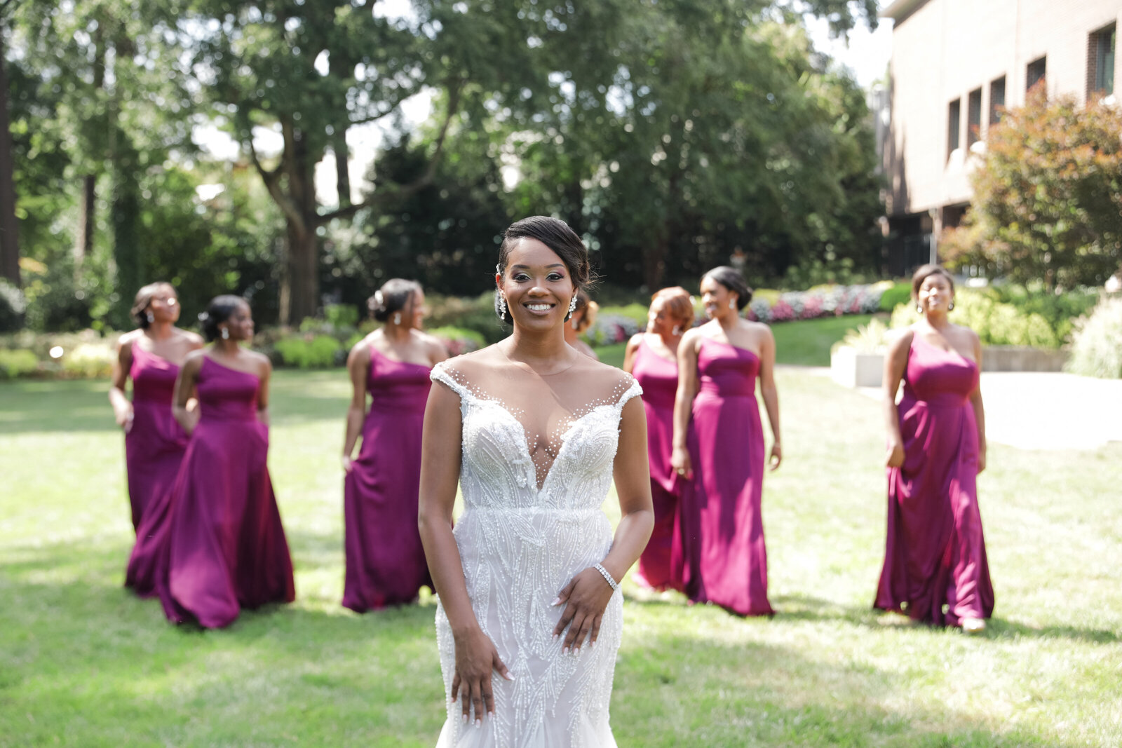 Stylish bride with her bridesmaids in a chic outdoor wedding, planned by a high-end wedding planner.