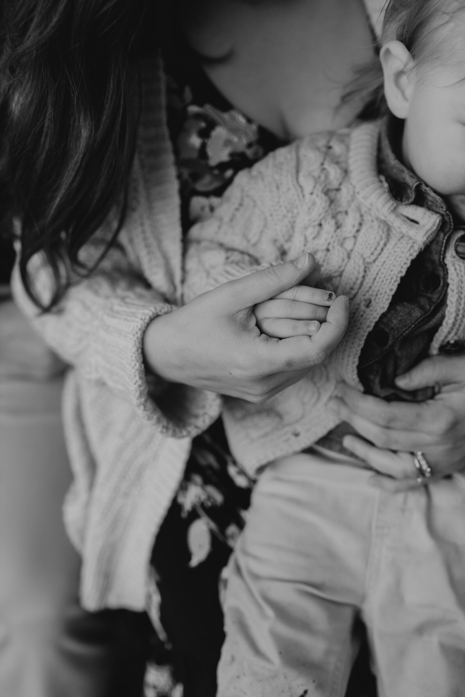 A mother holds her small child's hand