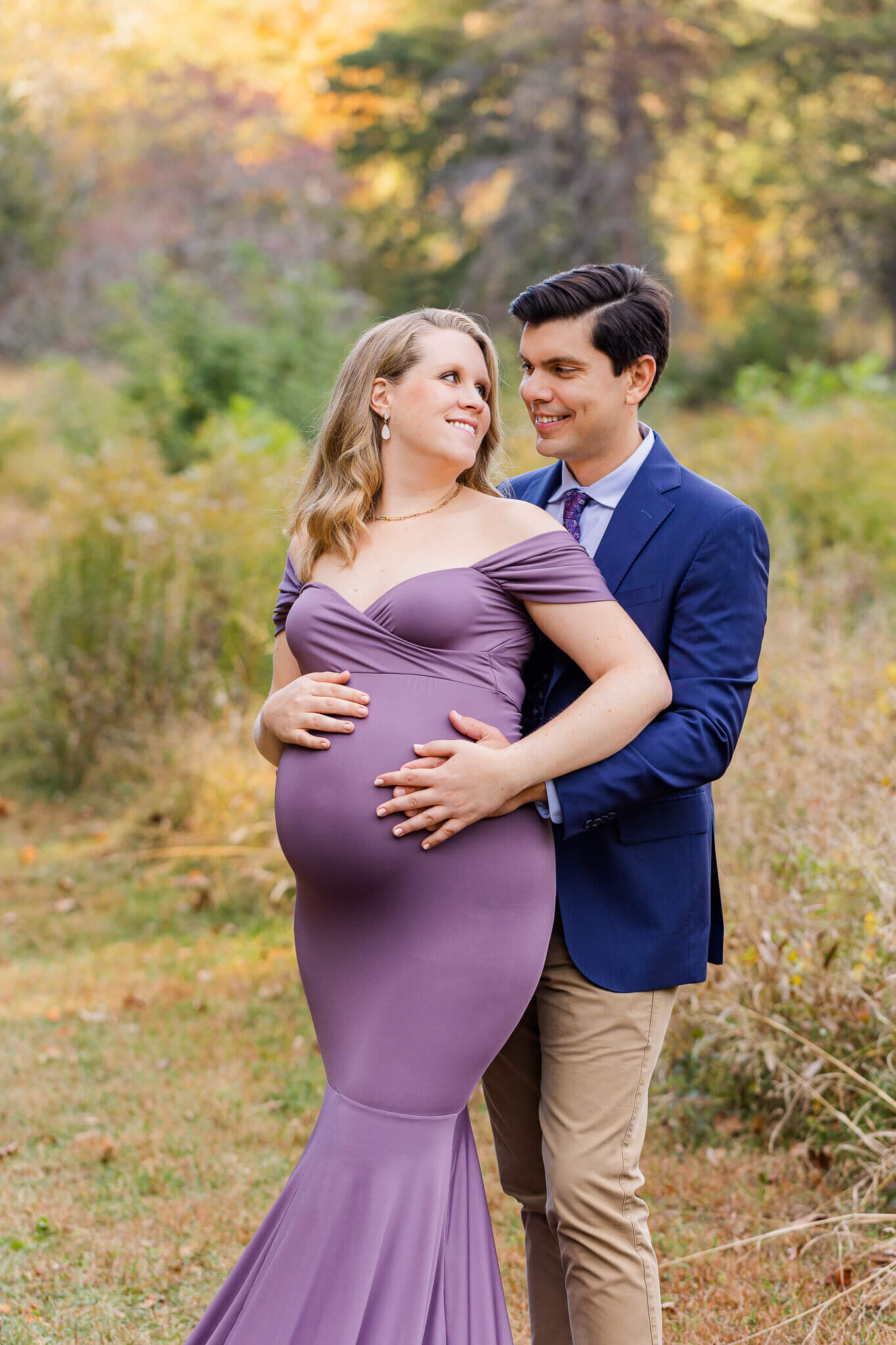 A pregnant couple posing for their maternity portraits.