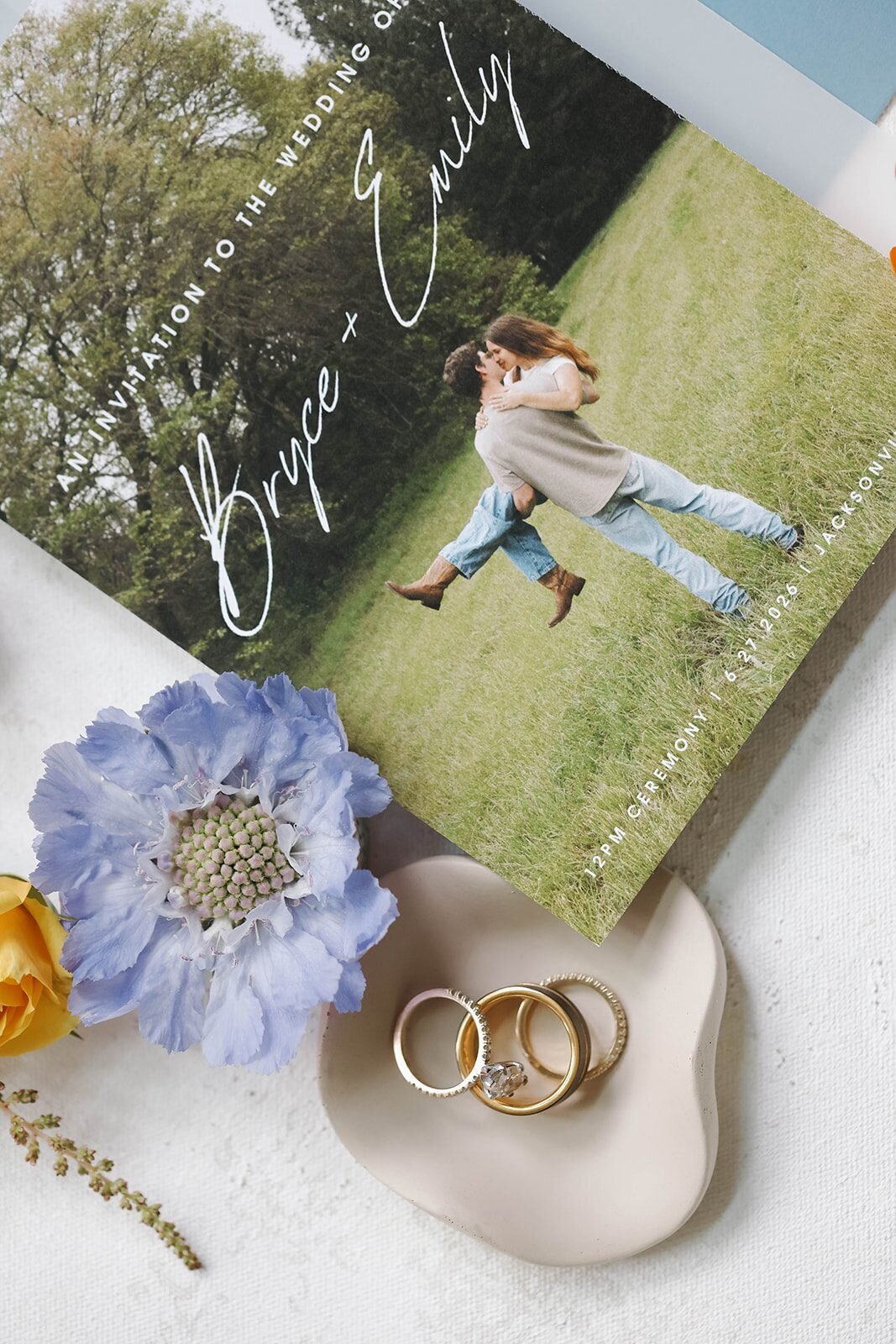 Wedding invitation, wedding rings and colorful flowers