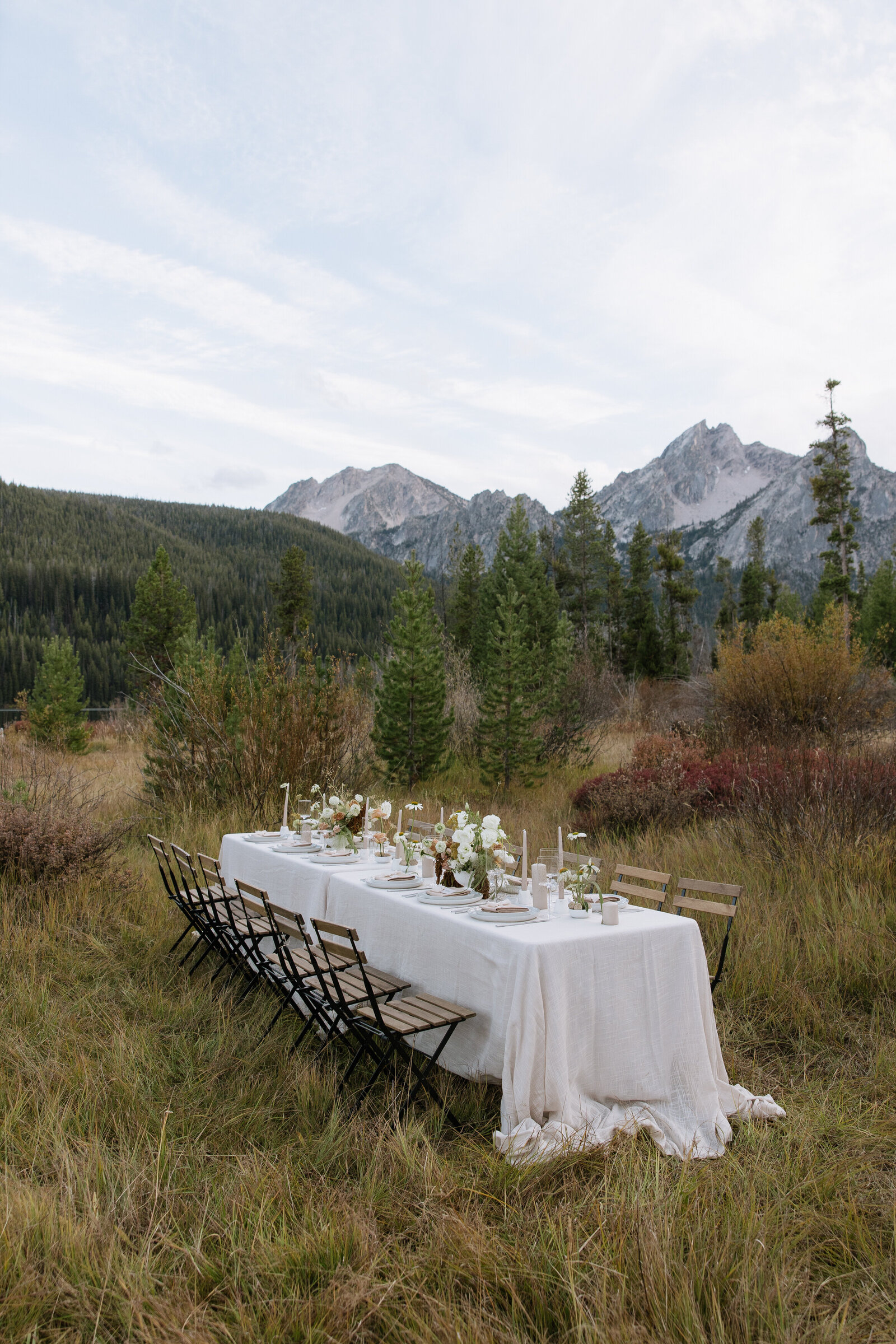 Intimate outdoor tablescape in peaceful meadow with view of the Sawtooth Mountains