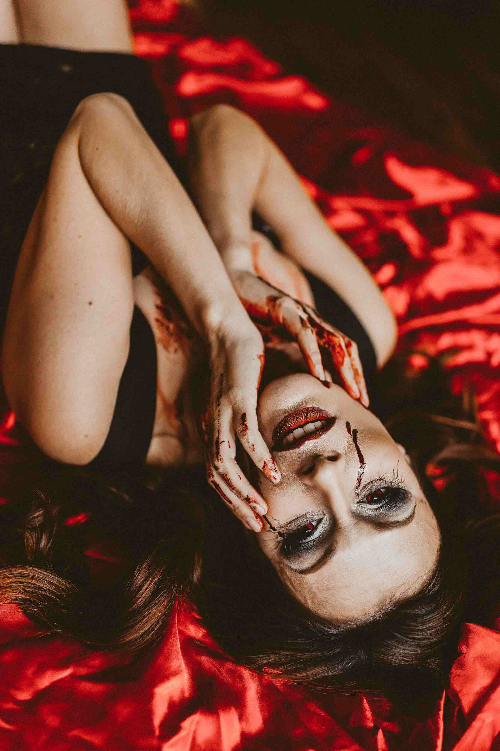 woman laying with a vampire make up