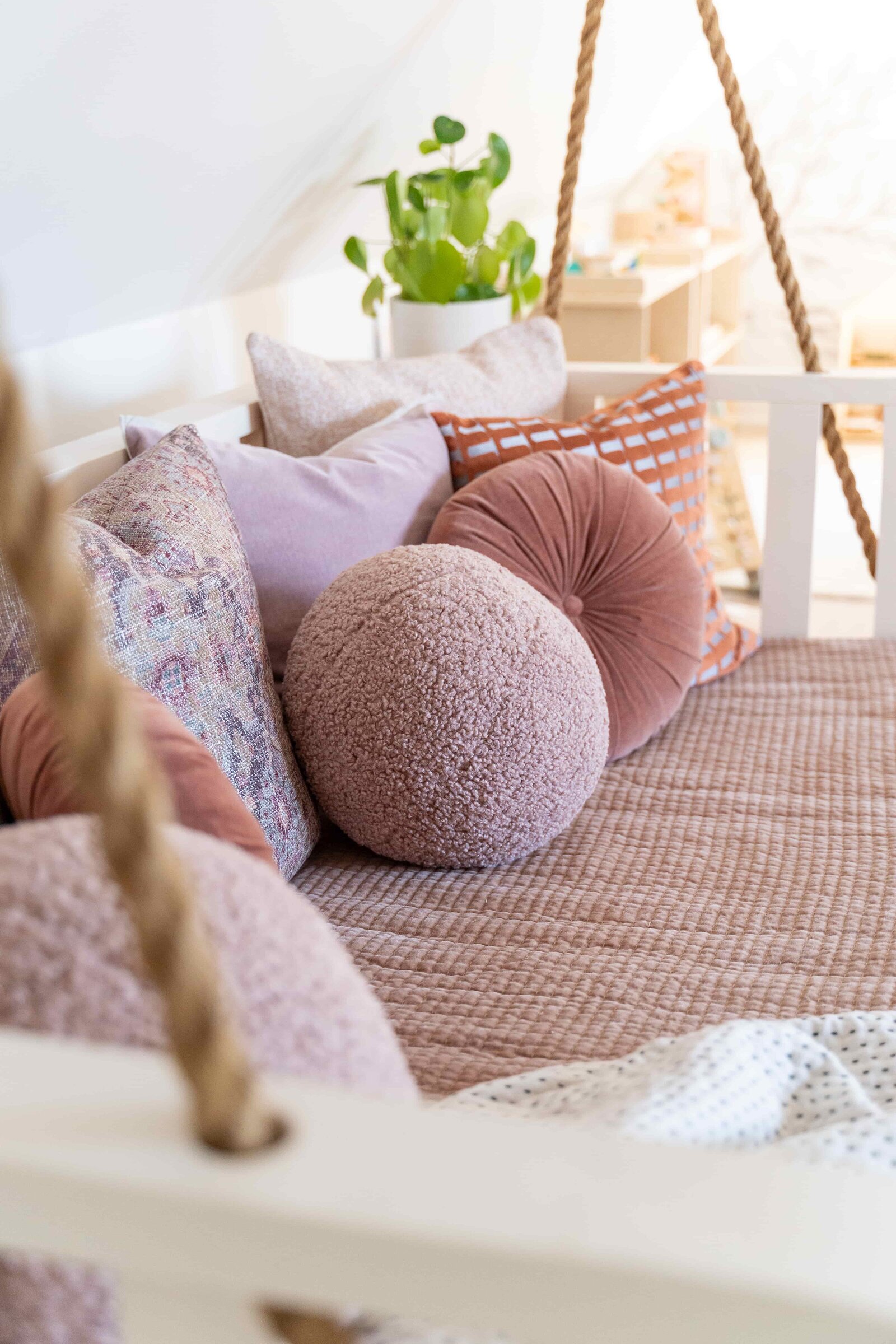 Pink and purple pillows on swing bench in playroom